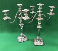 A pair of plated on copper two branch three light table candelabra