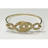 An 18 carat gold diamond encrusted double figure of 8 bangle, 19.