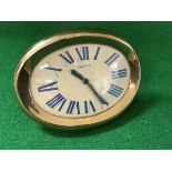 A Cartier travel clock of oval curved form,