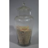 A late 19th/early 20th century apothecary's glass display jar having a slightly domed cover with