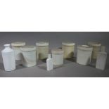 A set of six white pottery cylindrical jars and covers 15cm high and another smaller 12cm high