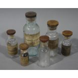 Six treen and Bakelite disc lidded clear glass medicine bottles,