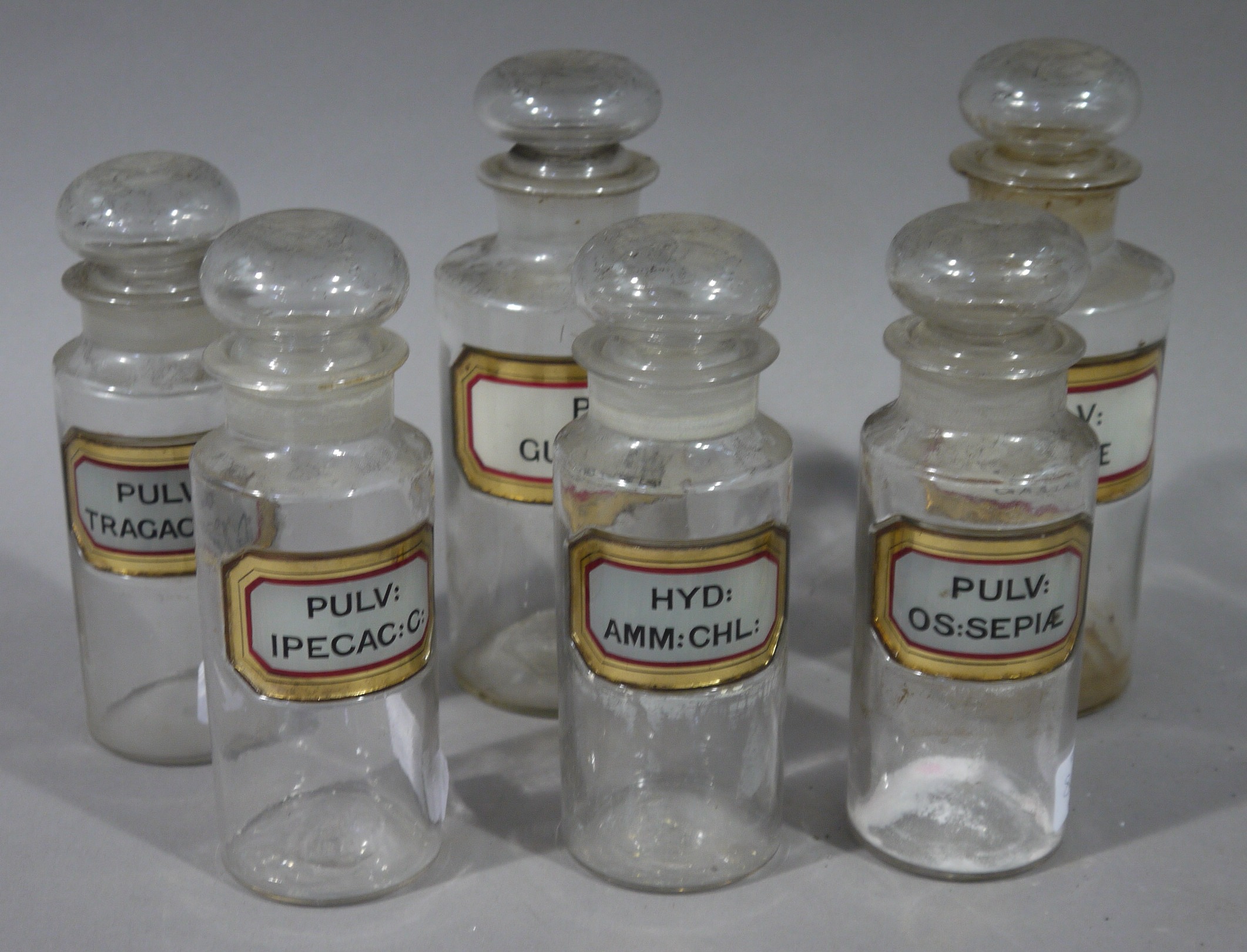 A set of six late 19th/early 20th century clear glass pharmacy bottles in two sizes, cylindrical, - Image 2 of 2