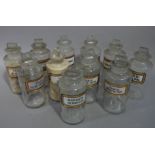 A near set of eleven late 19th/early 20th century clear glass pharmacy bottles, cylindrical,