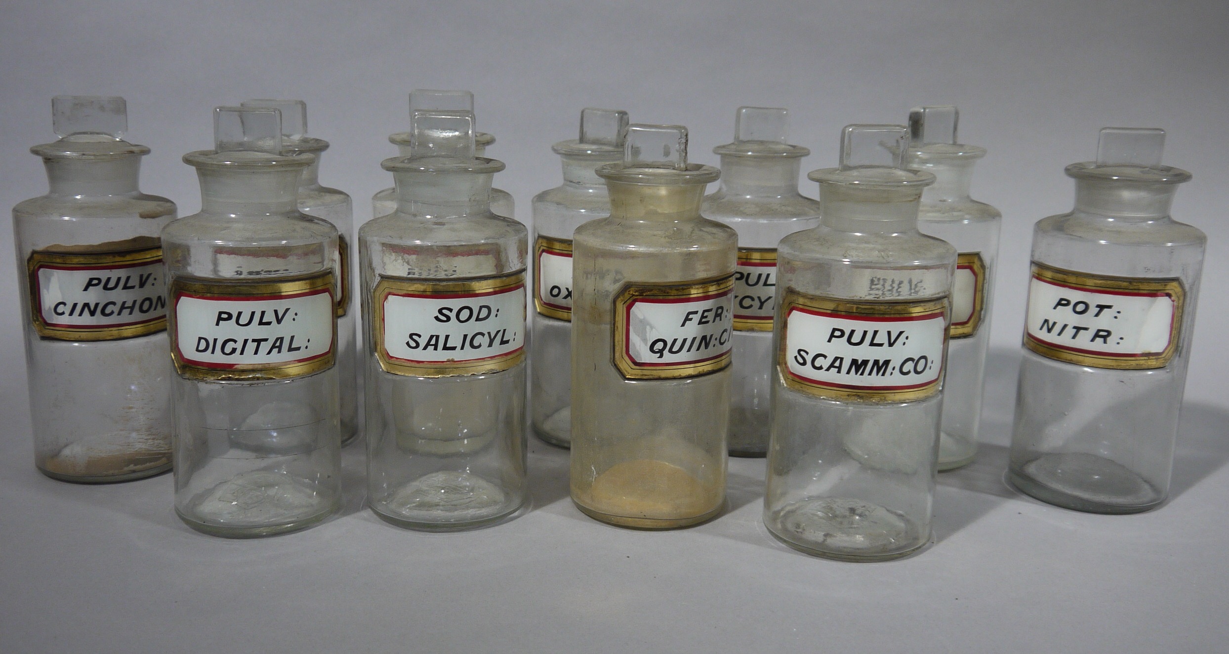 A set of eleven late 19th/early 20th century clear glass pharmacy bottles, cylindrical, - Image 2 of 3