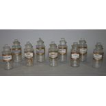 A set of nine late 19th/early 20th century clear glass pharmacy bottles, cylindrical,