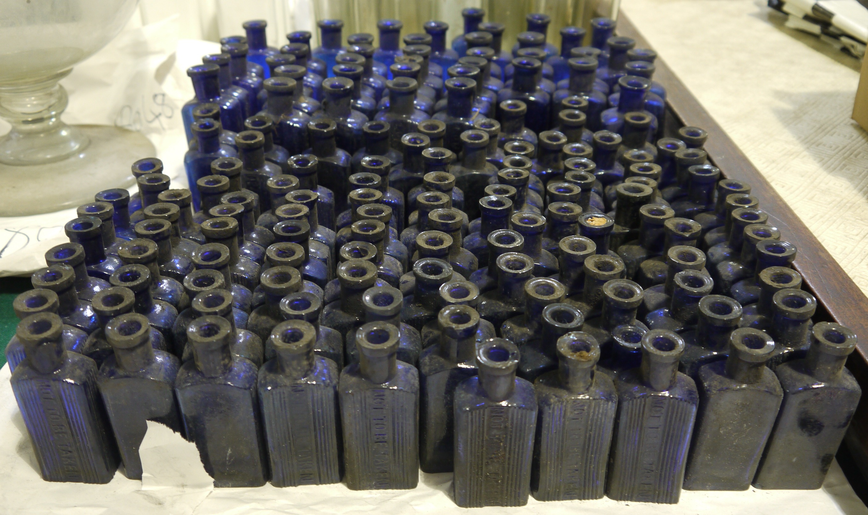 A quantity of blue glass pharmacy flask-shaped bottles, ribbed and moulded 'Not To Be Taken',