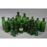 A quantity of green glass pharmacy bottles of cylindrical flask, hexagonal, ribbed and plain form,