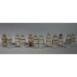 A near set of twelve late 19th/early 20th century clear glass pharmacy bottles, cylindrical,