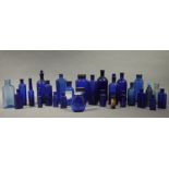 A quantity of blue glass pharmacy bottles of circular and flask shape,