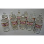 A set of seven late 19th/early 20th century clear glass pharmacy bottles, cylindrical,