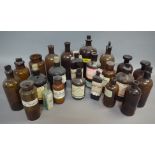 A collection of brown glass pharmacy bottles and jars, including two sealed bottles of Guy's Tonic,
