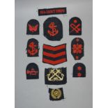 Small quantity of woven military badges worked in red and bullion thread