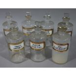 A set of seven late 19th/early 20th century clear glass pharmacy bottles, cylindrical,