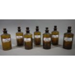 A set of seven late 19th/early 20th century brown glass pharmacy bottles, cylindrical,