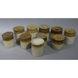 A set of ten early 20th century stoneware dipped jars and covers, cylindrical, with beaded border,