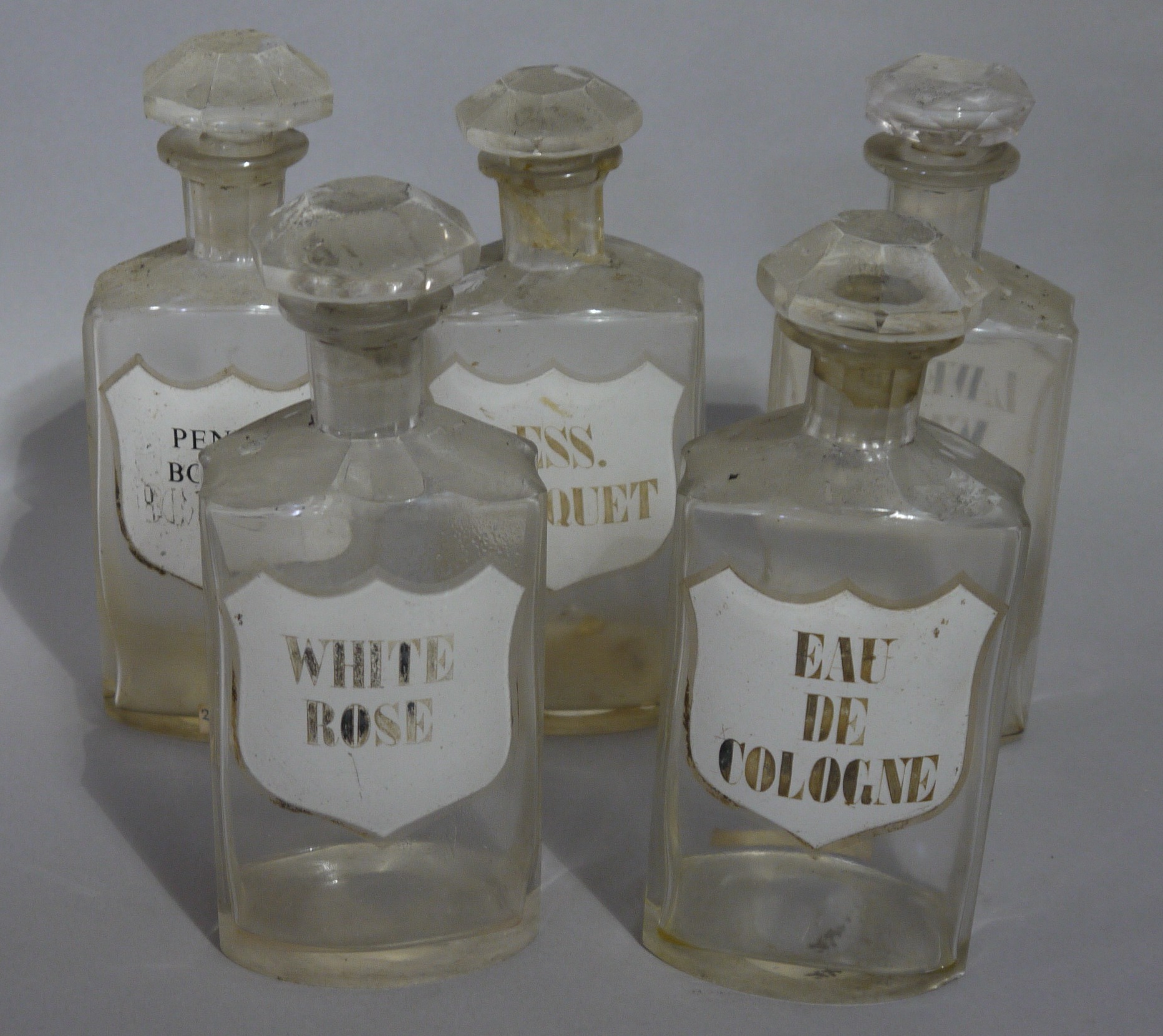 A set of five late 19th/early 20th century clear glass flask pharmacy bottles for toilet water each