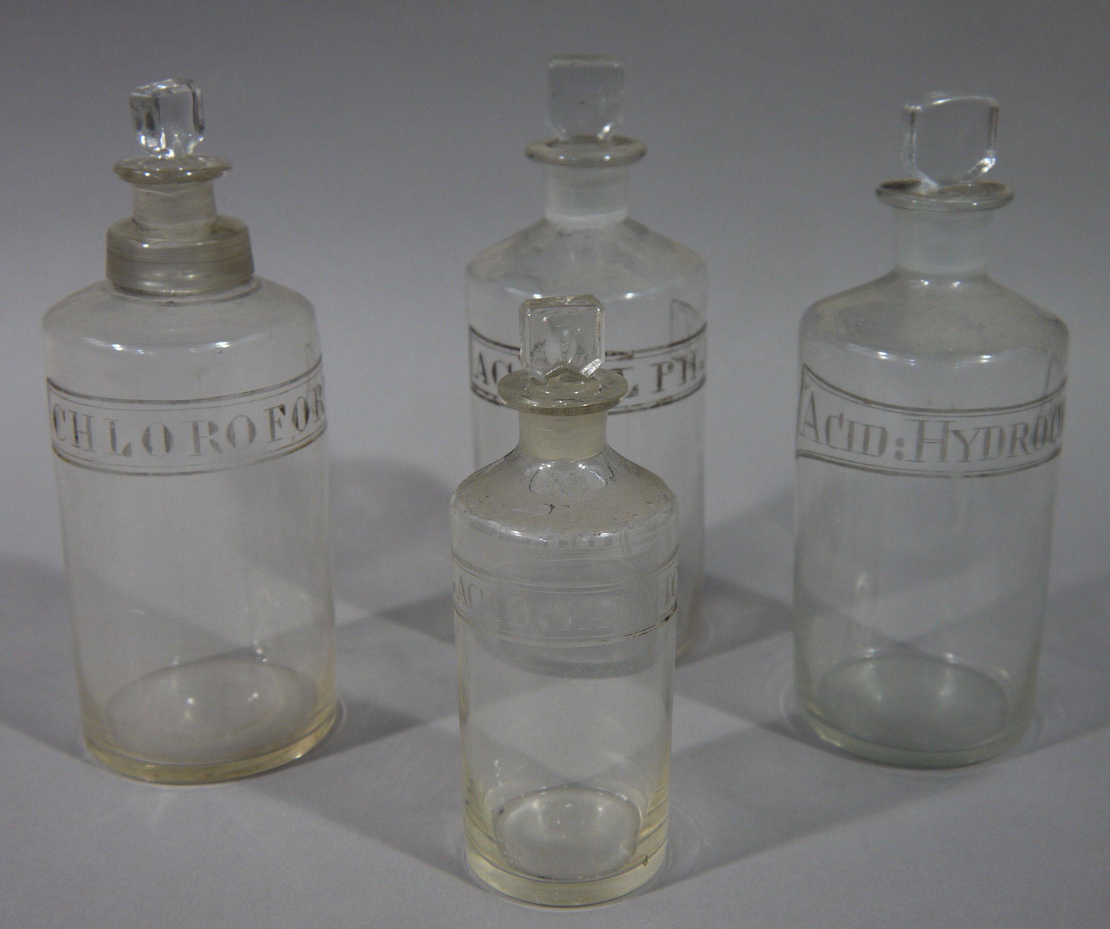 A 19th century pair and two similar clear glass pharmacy bottles, cylindrical, - Image 2 of 2