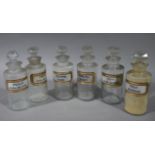 A set of six late 19th/early 20th century clear glass pharmacy bottles, cylindrical,