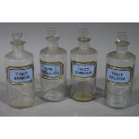 A set of four late 19th/early 20th century clear glass pharmacy bottles, cylindrical,