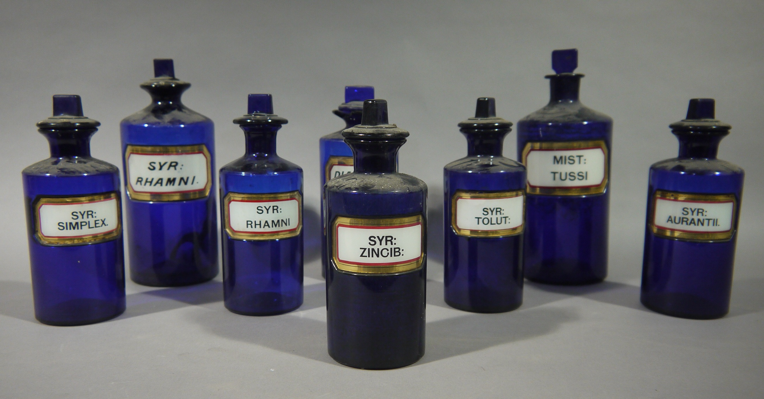 A set of five late 19th/early 20th century blue glass pharmacy bottles, cylindrical,