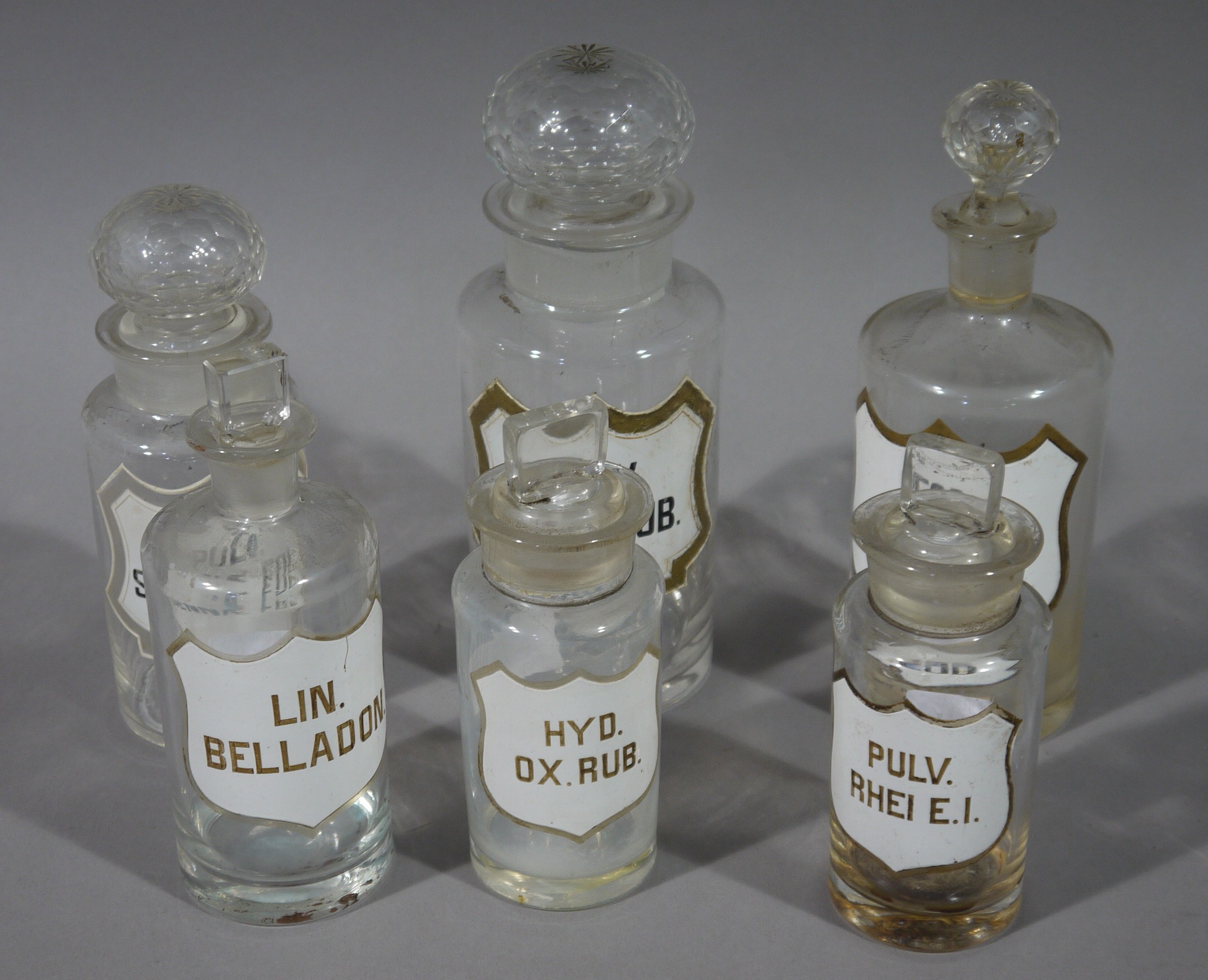 Six 19th century clear glass pharmacy bottles, cylindrical,