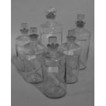 A set of five clear glass pharmacy bottles,