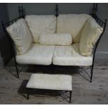 A metal frame two seater sofa with open spiral turned finials with loose cotton damask cushions,