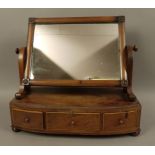 An early 19th century mahogany toilet mirror, having a rectangular glass,
