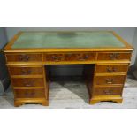 A reproduction yew veneered twin pedestal desk, the top with canted corners,