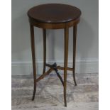 An Edwardian mahogany circular occasional table on slender square tapered legs joined by a rising