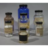 A set of seven clear and one blue glass pharmacy bottle with black screw cap,