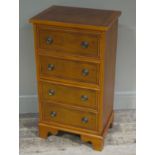 A reproduction yew wood chest of four drawers on shaped bracket feet,