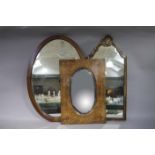 An Edwardian mahogany oval wall mirror with bevelled glass together with a walnut wall mirror of