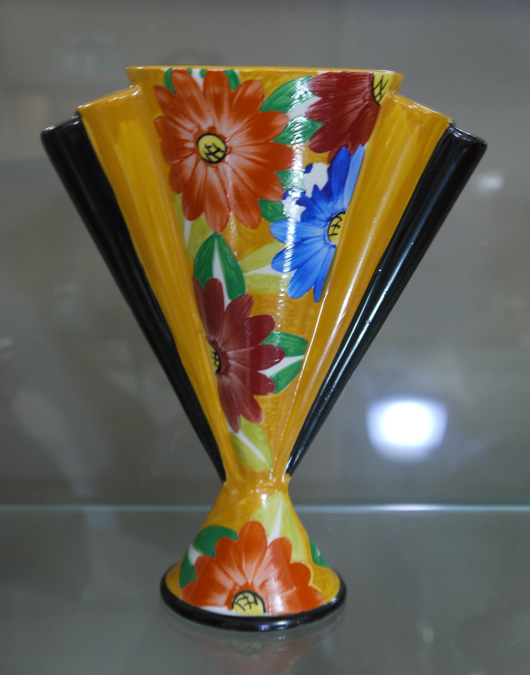 A Dean Sherwin ceramic vase in Deco style, fan shaped with flowers in yellow and black, 18.