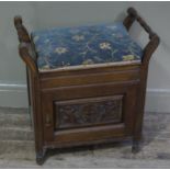 A late Victorian walnut piano stool with upholstered hinged top and single door cupboard below with