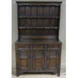 An early 20th century oak dresser and rack having a moulded cornice above a planked back and three