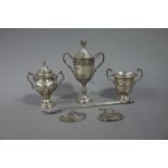 A silver two handled trophy cup and cover embossed with a border of grapevine above an engraved