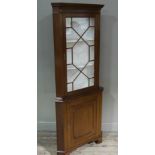 A mahogany corner standing cupboard having a moulded and dentil cornice above tracery glazed doors