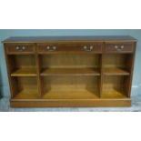 A reproduction yew wood book case having three drawers across and book shelves below,