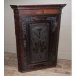 A 19th century oak hall cupboard having a moulded and dentil cornice above a mahogany veneered