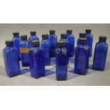 A set of fourteen blue glass pharmacy bottles, rectangular with black screw cap,