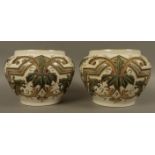 An interesting pair of Victorian pottery jardinieres the bodies decorated with floral cartouches