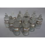 A set of twelve bottles late 19th/early 20th century clear glass pharmacy bottles, cylindrical,