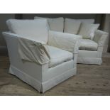 A two seater sofa and armchair upholstered in pale cream with scatter cushions