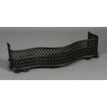 A Victorian cast iron fender of serpentine outline and trellis design on bun feet 106cm wide x 35cm