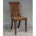 A 19th century mahogany hall chair having indented panelled back and on turned legs