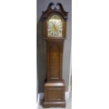 A reproduction oak long case clock having a swan neck pediment with urn finial above an arched