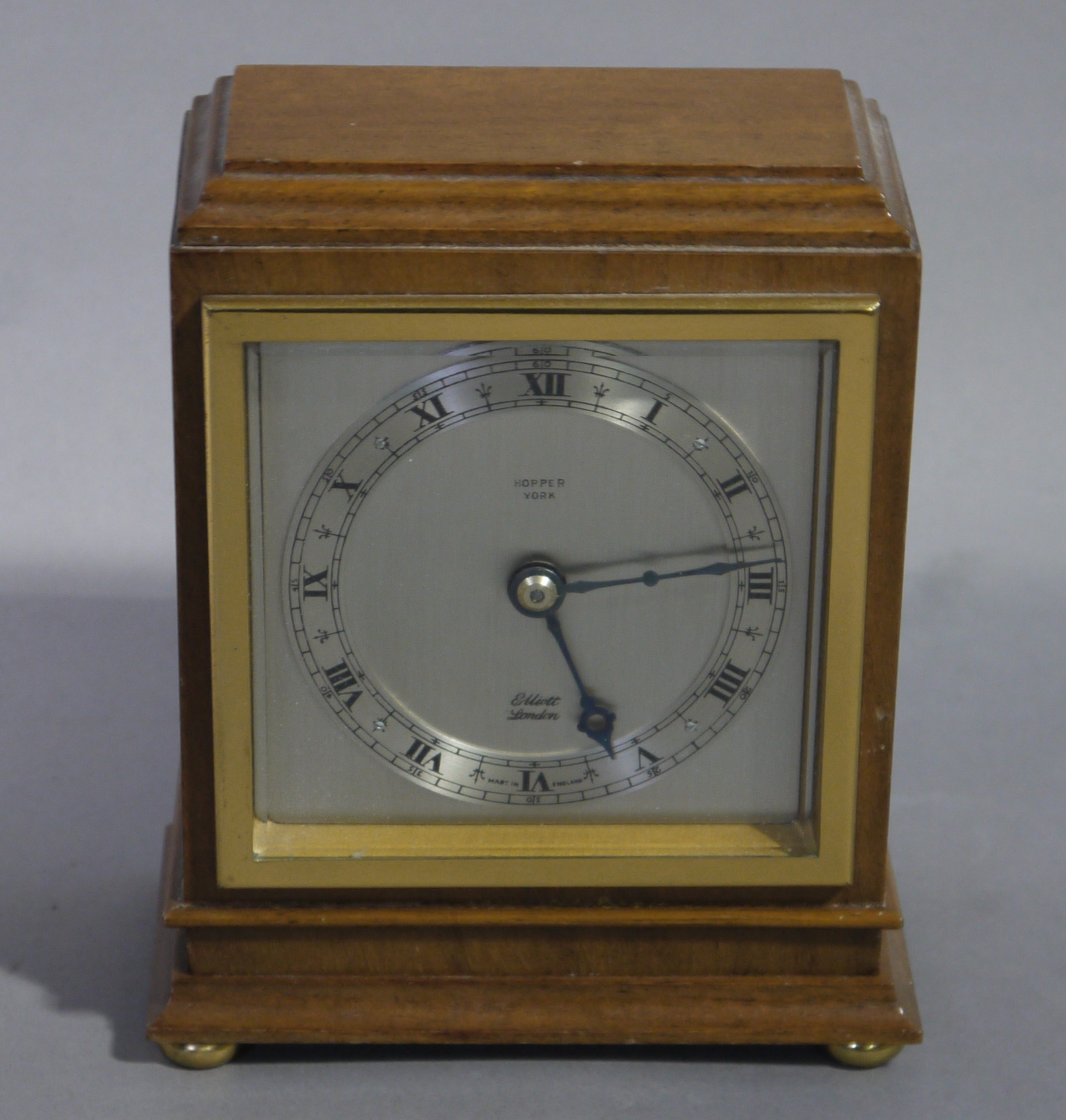 An Elliott walnut mantel clock of square stepped outline with brass bezel and bun feet, - Image 2 of 2