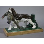 A painted white metal lighter modeled as a gun dog with pheasant in its mouth standing before a
